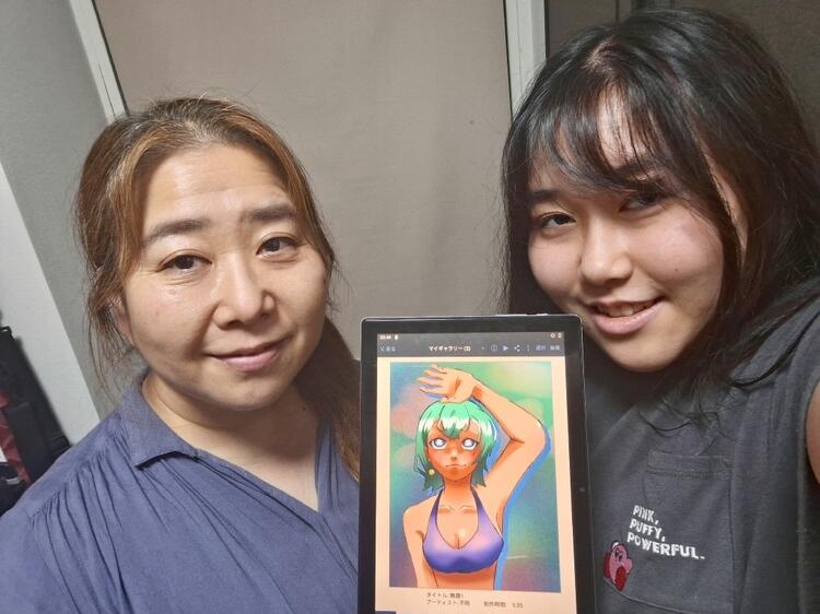 生徒と保護者が生徒が描いたお気に入りのイラストを持ったツーショット写真