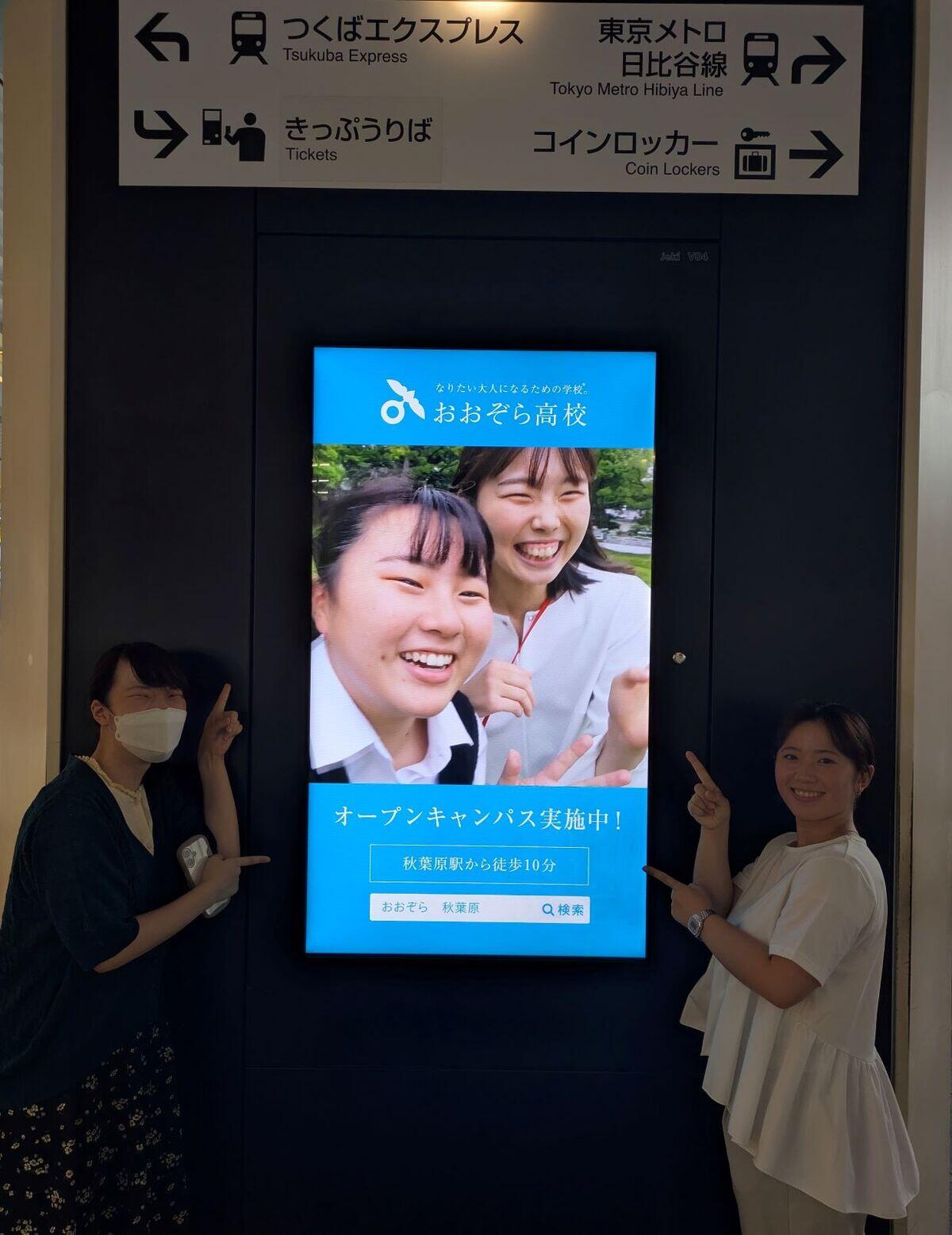 秋葉原駅に出ているおおぞら高校のデジタルサイネージの前でコーチが撮った写真