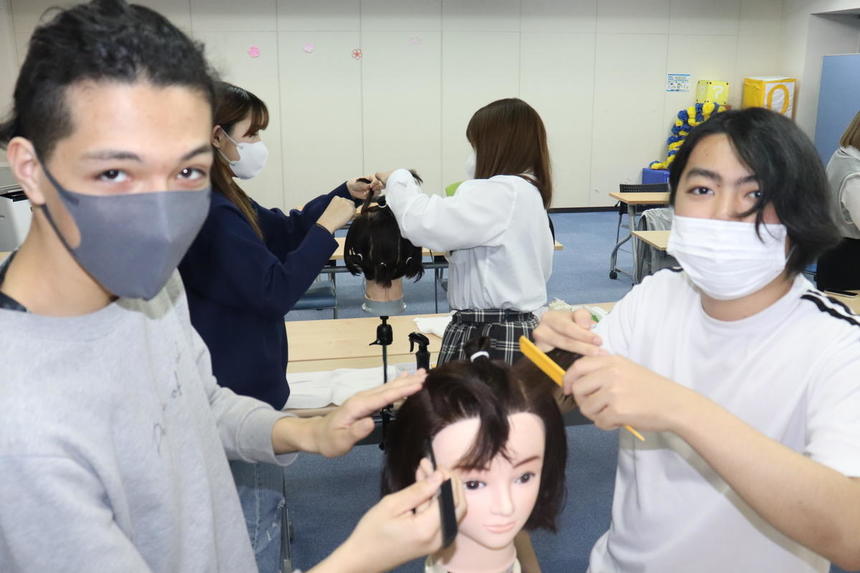美容師の技術訓練をする高校生たち