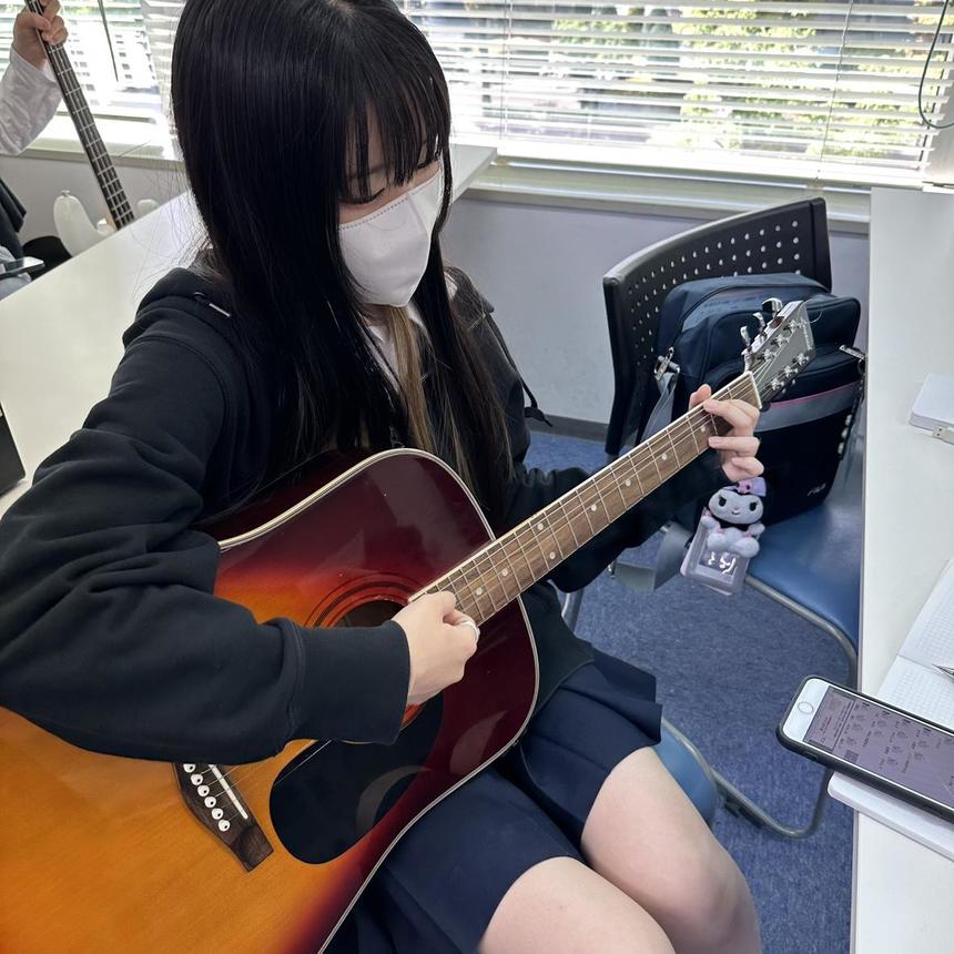 ギターを弾く女子生徒