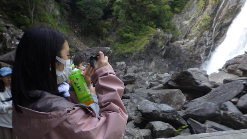 滝を撮影する高校生