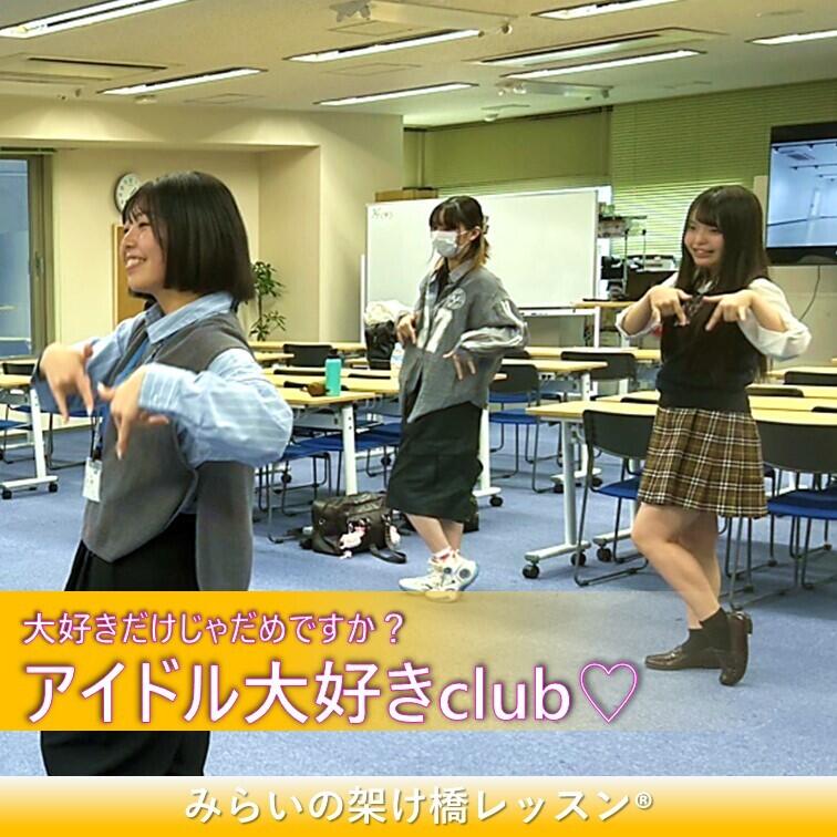 二人の生徒とコーチが教室でアイドルソングを踊っている写真