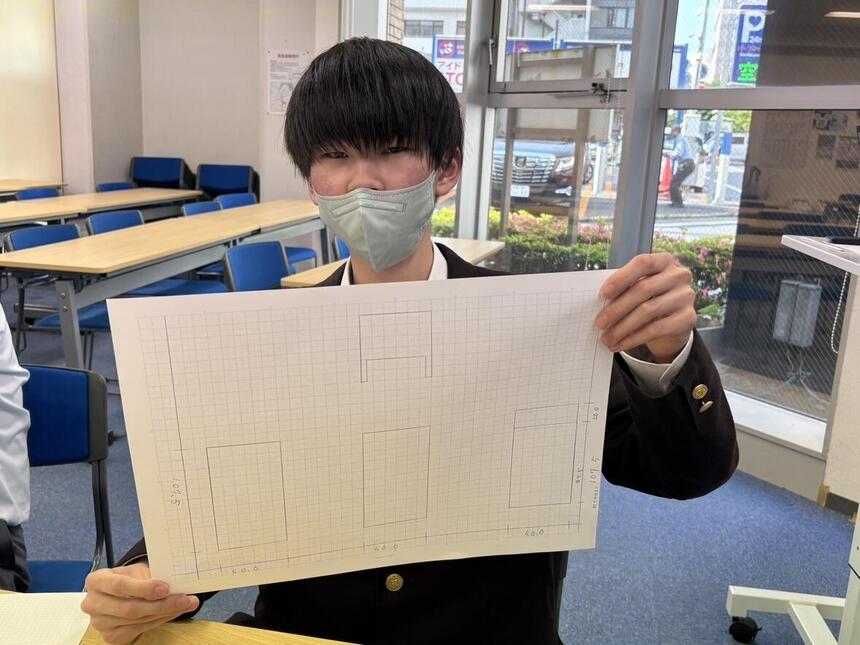 自分で描いた図面をもって、見せてくれている様子