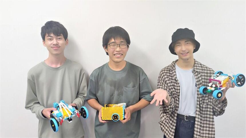 ロボットを持った生徒が3名ポーズを取っている