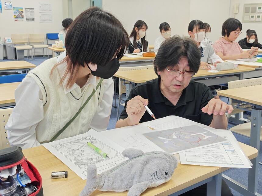 女子生徒が講師の方にマンガを教わっている