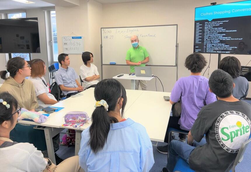 外国人講師と生徒10名が一緒に輪になってグループワークしている様子