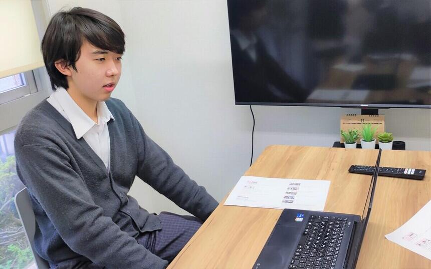 男子高校生がパソコンの前で発表している様子