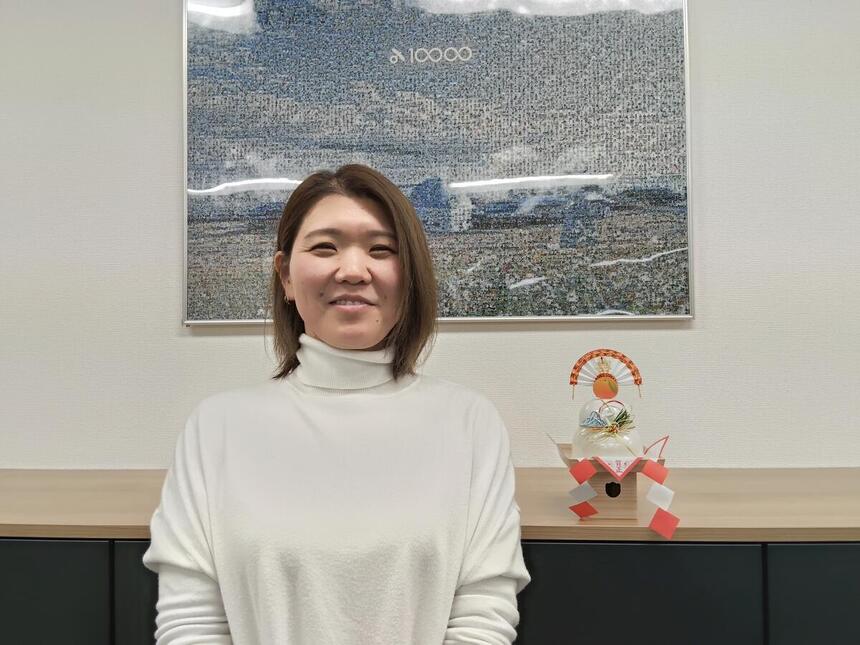 女性スタッフが鏡餅と一緒にポーズを取っている