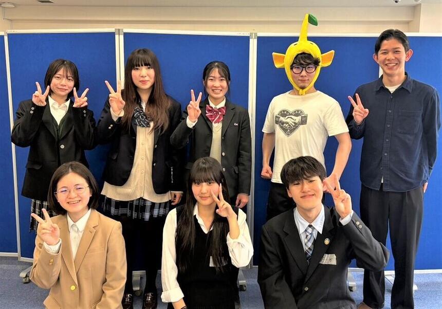 生徒男女8名が笑顔でポースを取っている様子