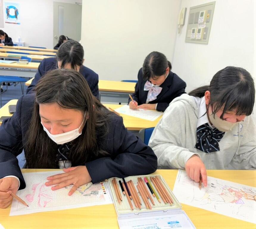 4人の女子生徒たちが塗り絵をしながら話しています
