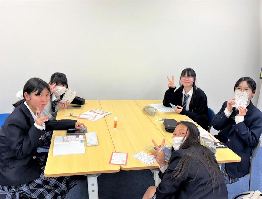 5人の女子生徒がノートを使ってコミュニケーションしている様子