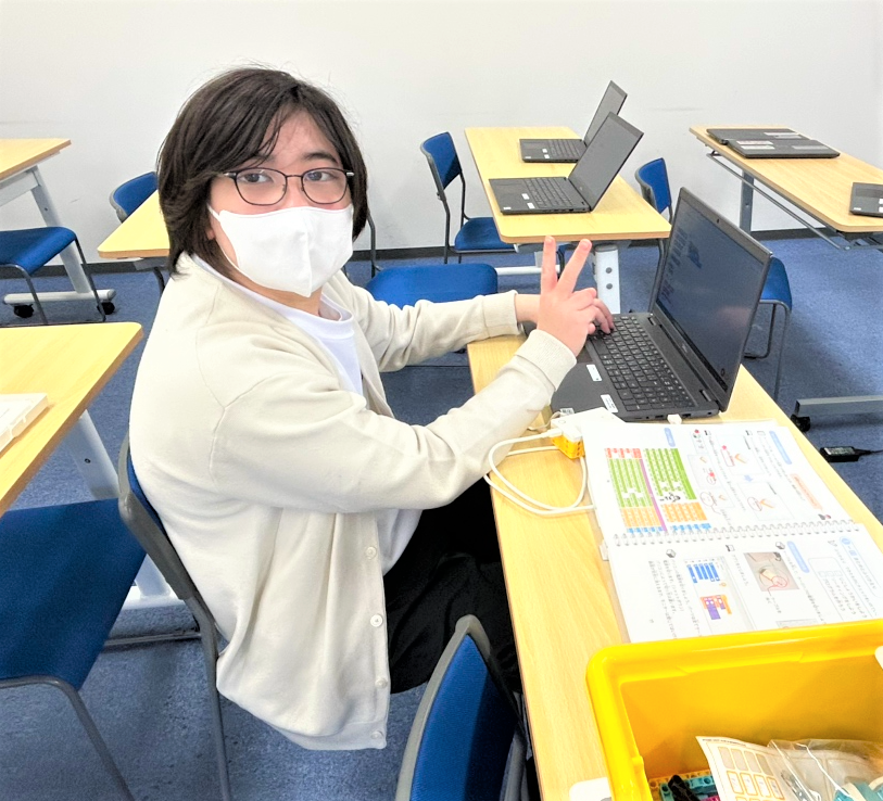 男子生徒がパソコンの前でプログラムしている様子