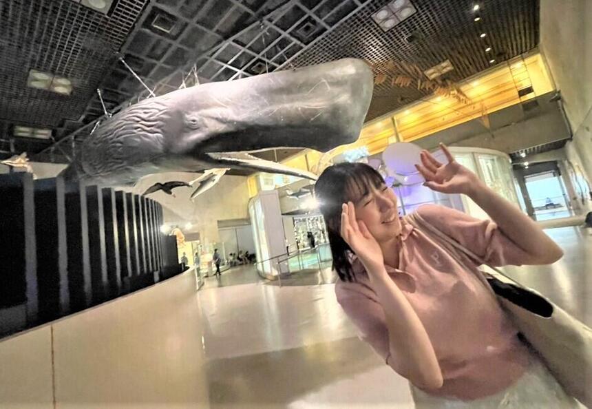 博物館にてクジラに食べられるようにポースを取る女性