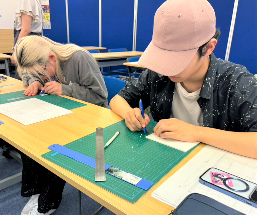 教室内にて男子生徒と女子生徒がスチレンボードを切って作業している様子