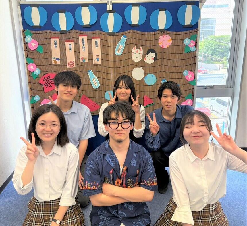 縁日のフォトブース前にて男女６人の高校生がポーズをしている様子
