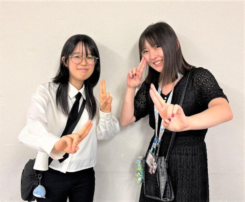 室内にて女性コーチと女子高生1名が二人でポーズを取っている様子