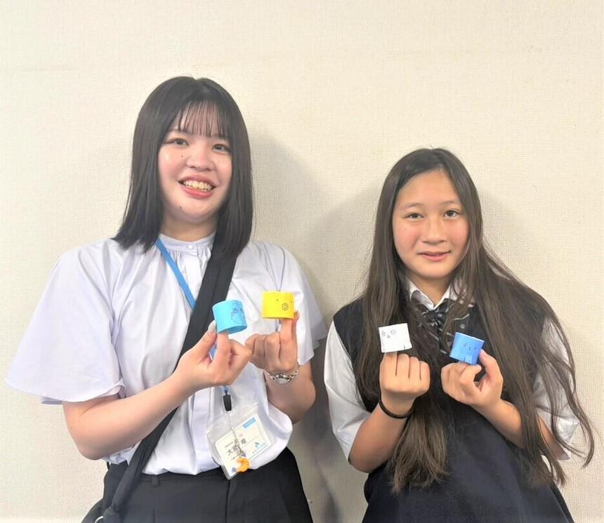 女子生徒とマイコーチが作成物を持って記念撮影している様子