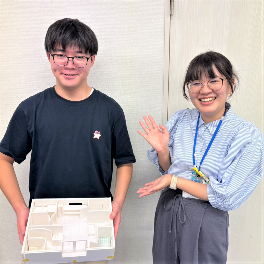 男子生徒が作成した模型を持って、マイコーチ®とポーズをしている様子