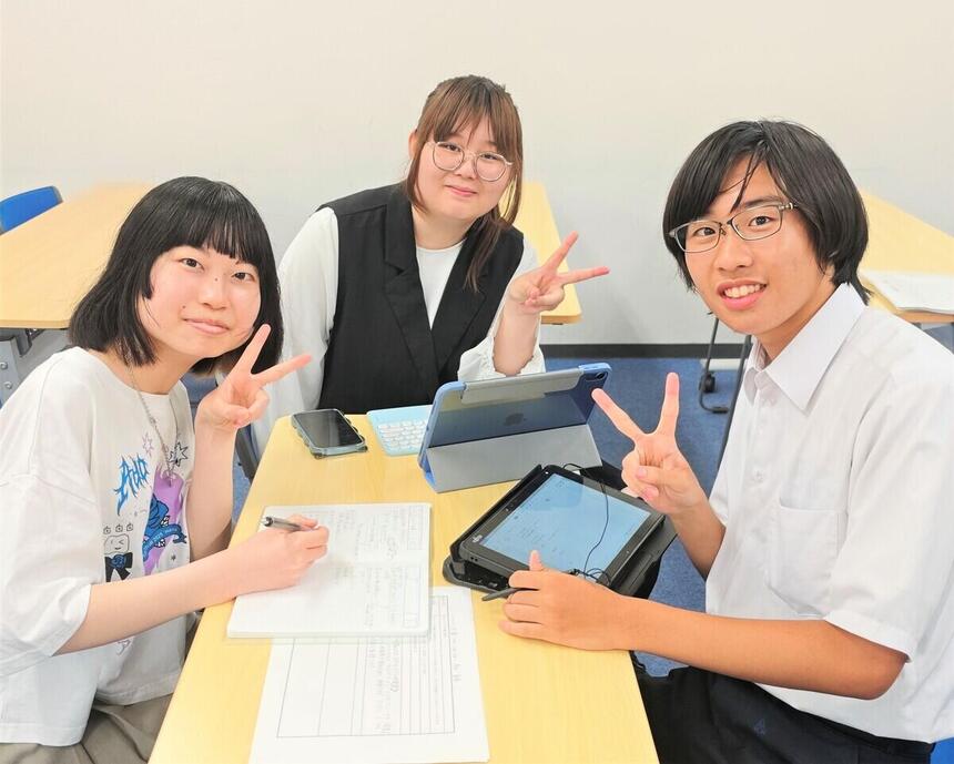女子高校生2名と男子高校生1名が一緒に話し合いをしている様子