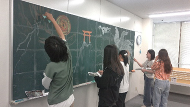 5月28日に教室で生徒たちで協力して黒板アートに取り組んでいる様子
