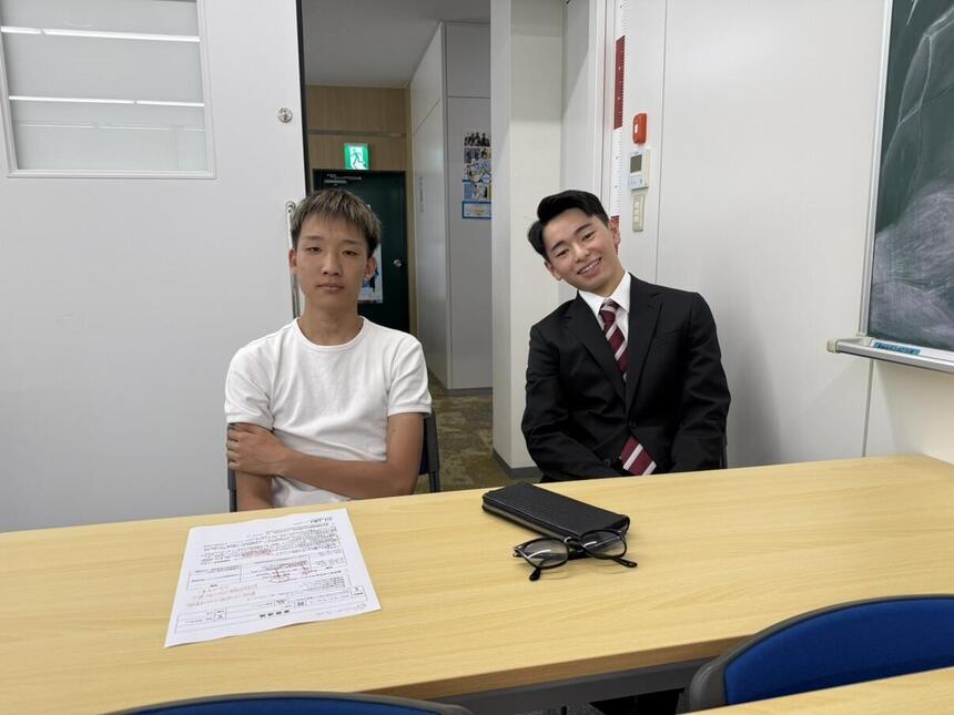 転校生とその友人の2ショット写真。転校の経緯について楽しく話している状況。