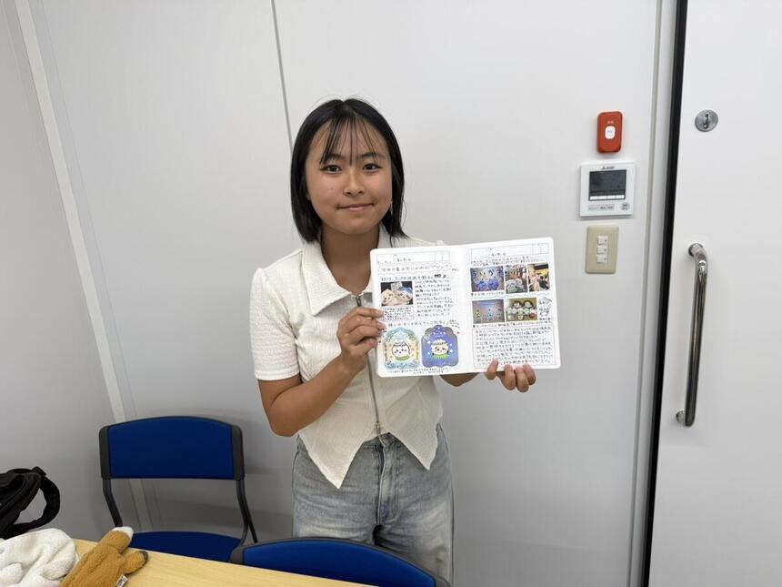 夏休みの思い出を書いたみらいノートを見せてくれている生徒の写真