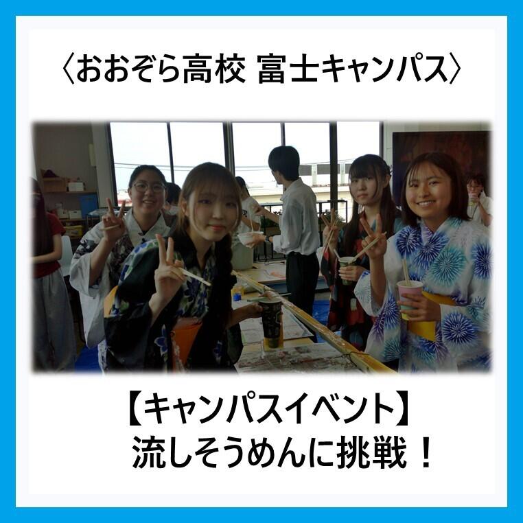 富士キャンパス内で竹を使用した流しそうめんのコースの前で浴衣を着て流しそうめんを楽しむ生徒の写真