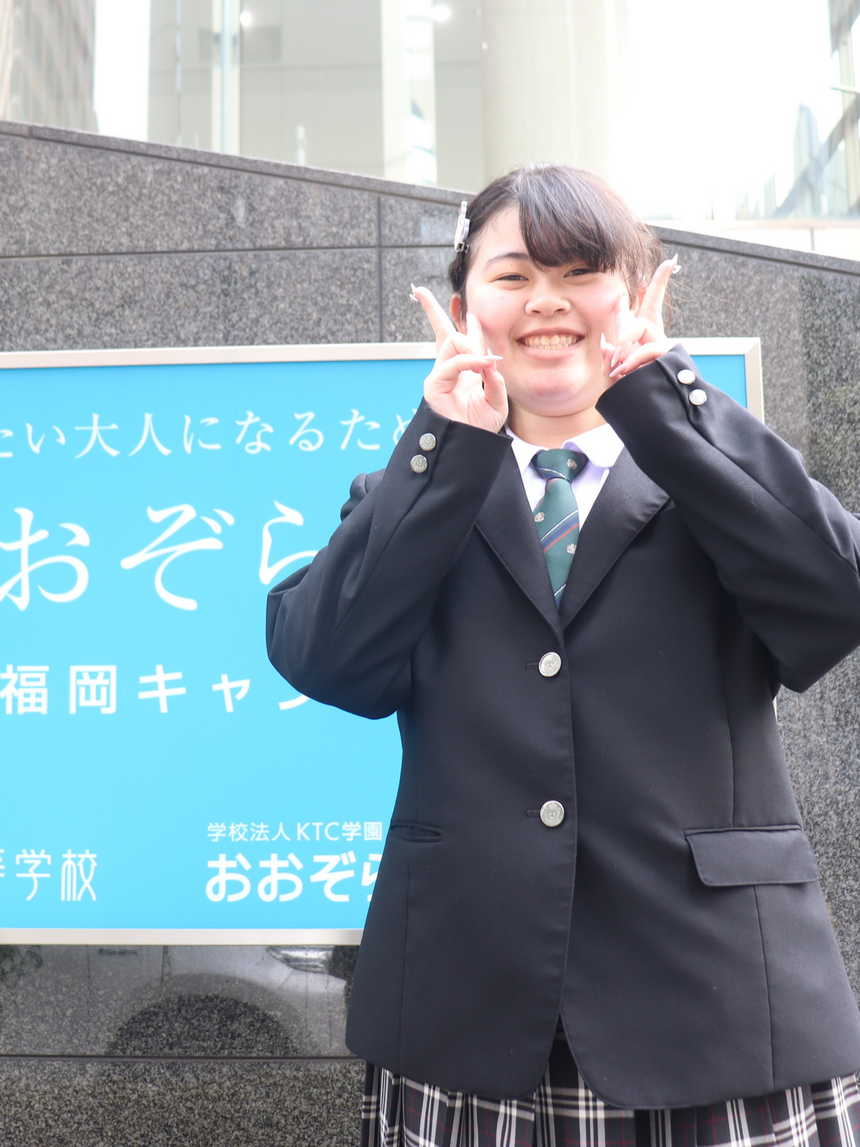 進路が決まってピースをしている女子生徒