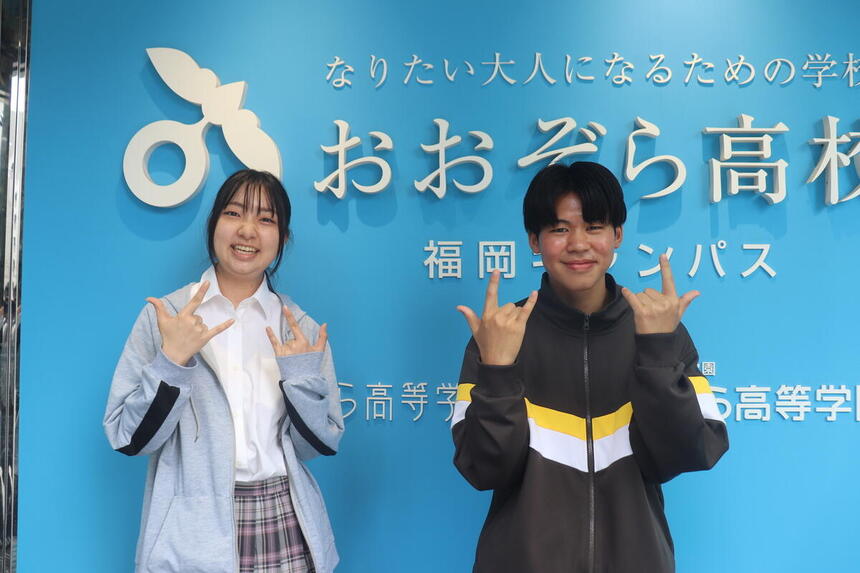 生徒二人がこちらを向いて笑顔でポーズを取っている様子
