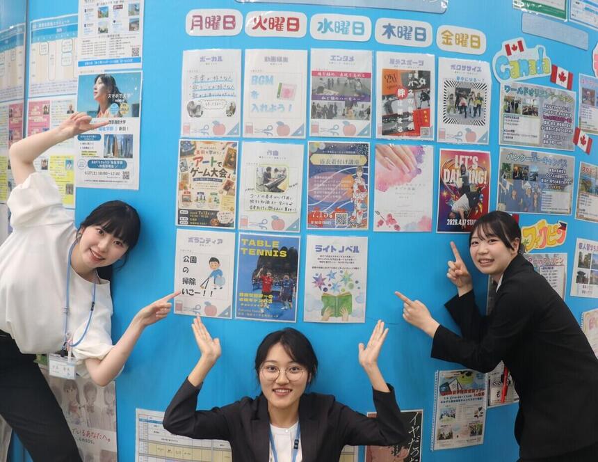 みらいの架け橋レッスンのポスターを掲示している壁と紹介するコーチ