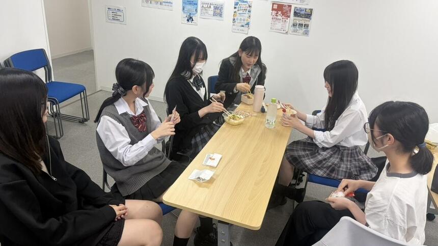 生徒がキャンパスでお昼休みの時間に集まって楽しく食事をしている様子