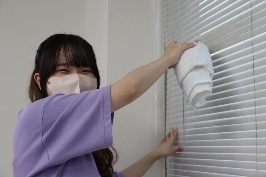 笑顔でキャンパスの大掃除をする生徒