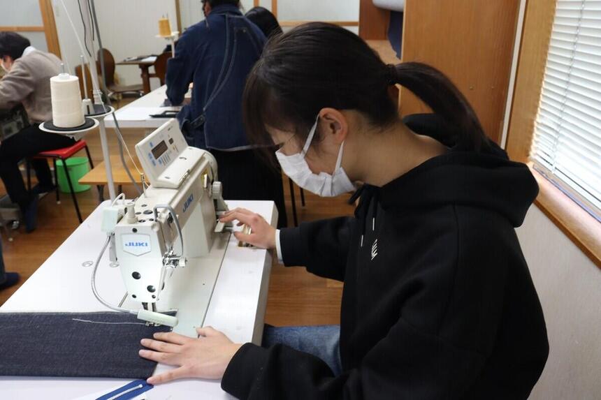 デニム工場で職場体験をする生徒