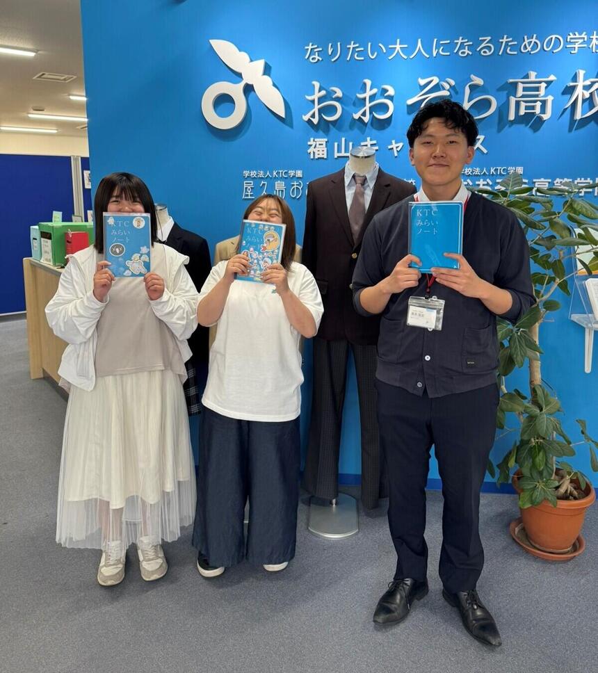 インタビュー対象生徒と福山キャンパス入り口でKTCみらいノート®を持って撮影した写真