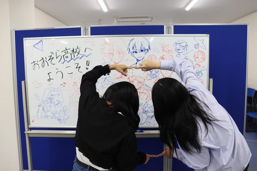 福山キャンパスにてウエルカムボードの前でポーズを取っている女子生徒の様子。