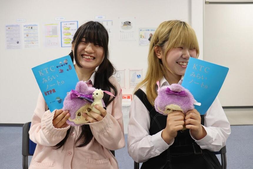 キャンパスで女子生徒が友だちと一緒にみらいノート®を持っている写真