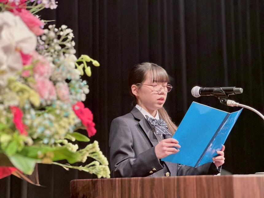 入学式で生徒が代表挨拶を読んでいる様子