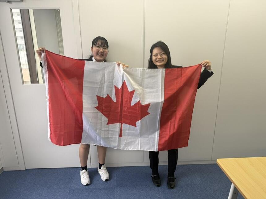 生徒とコーチがカナダの国旗を持っている画像