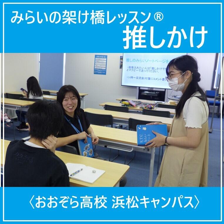 生徒2人とコーチ1人がノートを持って話し合う様子