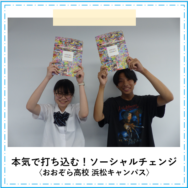 ソーシャルチェンジに参加する二人の生徒がソーシャルチェンジで使用する教科書を上に掲げて笑顔でいる様子