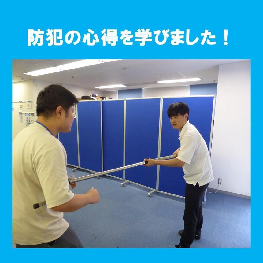 防犯講習にてコーチがさすまたの使い方を練習している様子