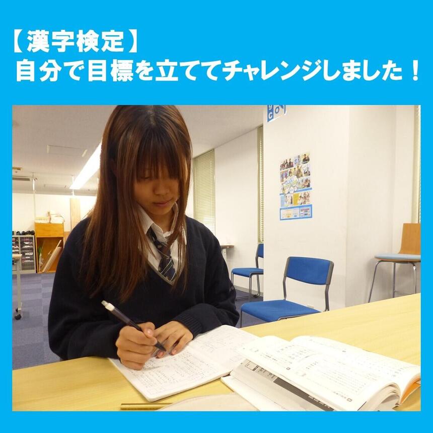 教室で生徒が参考書の問題を真剣に勉強している様子