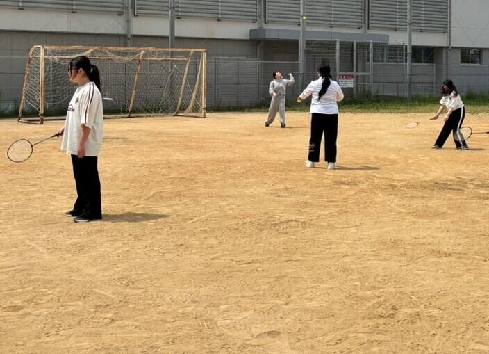 グラウンドで、みらいの架け橋レッスン「スポーツ」のバドミントンを楽しんでいる生徒の様子