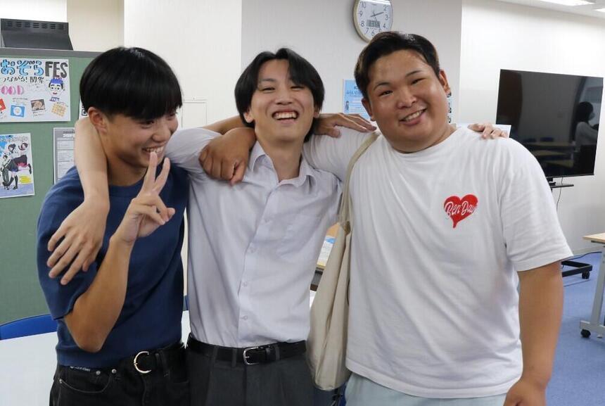 教室で男子生徒3名が肩を組んで笑っている写真