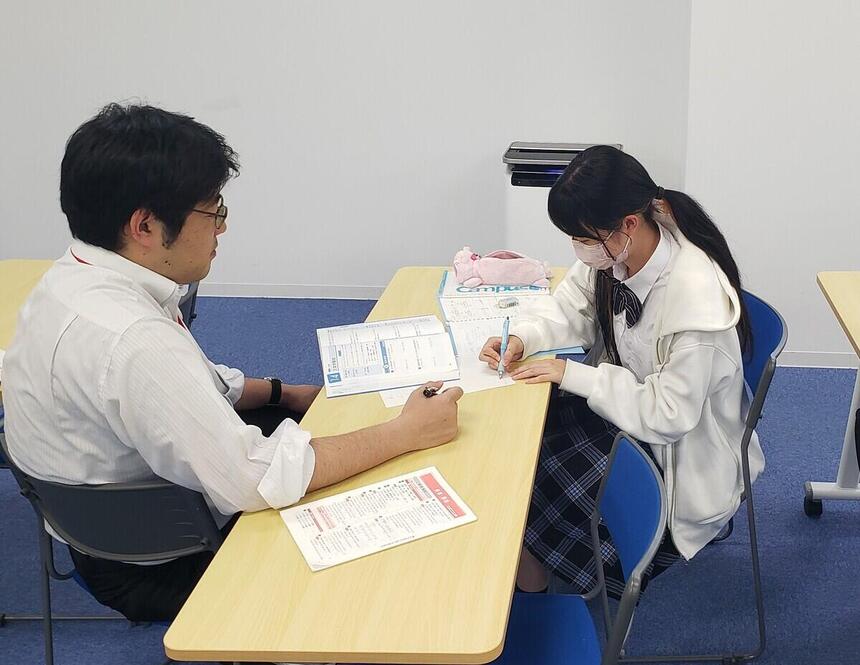 勉強をする生徒と教えるコーチ