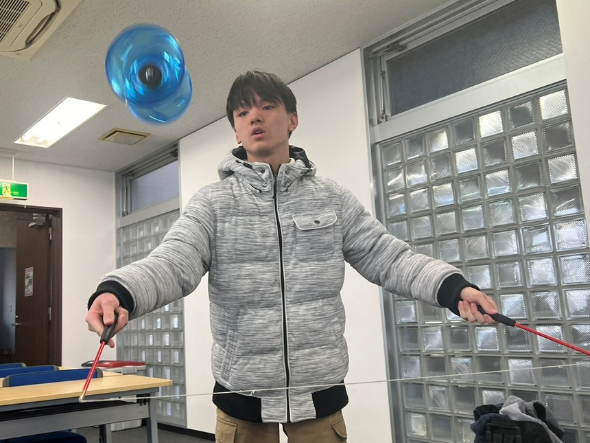 2年次の男子生徒がみらいの架け橋レッスンで中国ゴマを練習している写真
