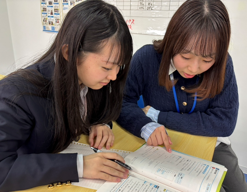 キャンパスの教室で行われているみらいの架け橋レッスン®で、生徒がコーチにわからない問題の解き方を教えてもらっている様子