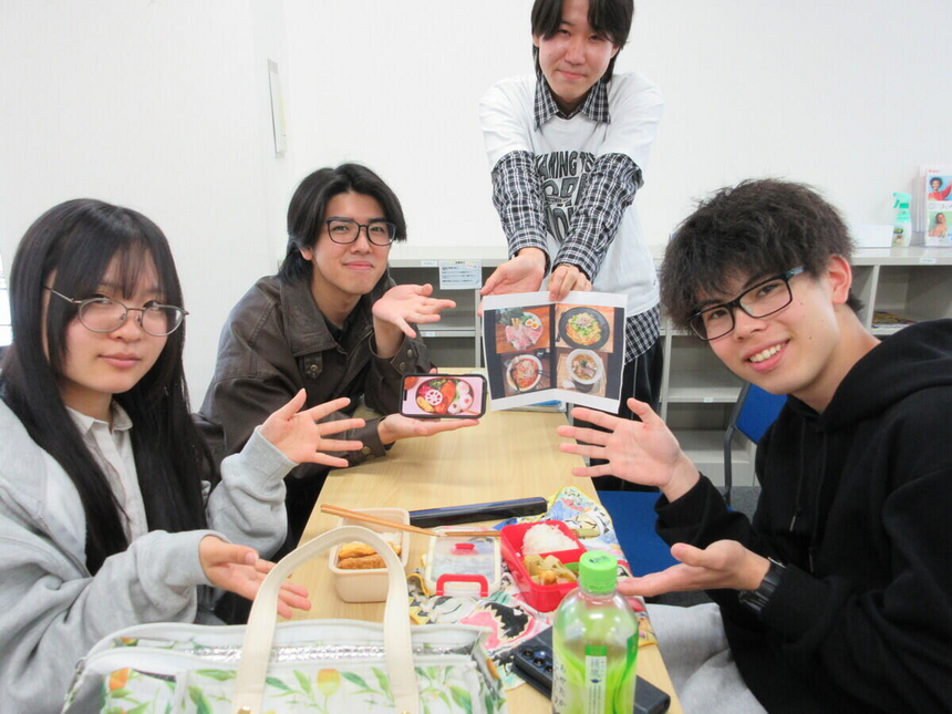 キャンパスの教室で生徒たちがお弁当を広げて楽しく昼食をとっている様子