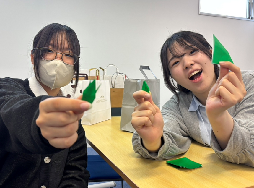 キャンパスの教室でおおぞらアンバサダーの生徒たちが折った鶴を手に色分けをしている様子