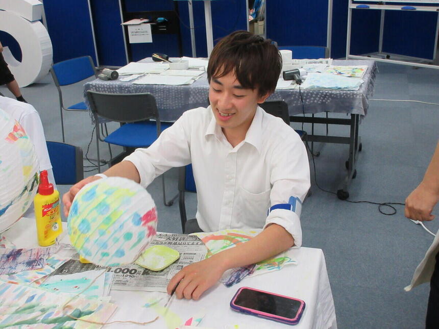 キャンパスの教室で体験授業中に中学生と一緒に在校生が制作に取り組んでいる様子